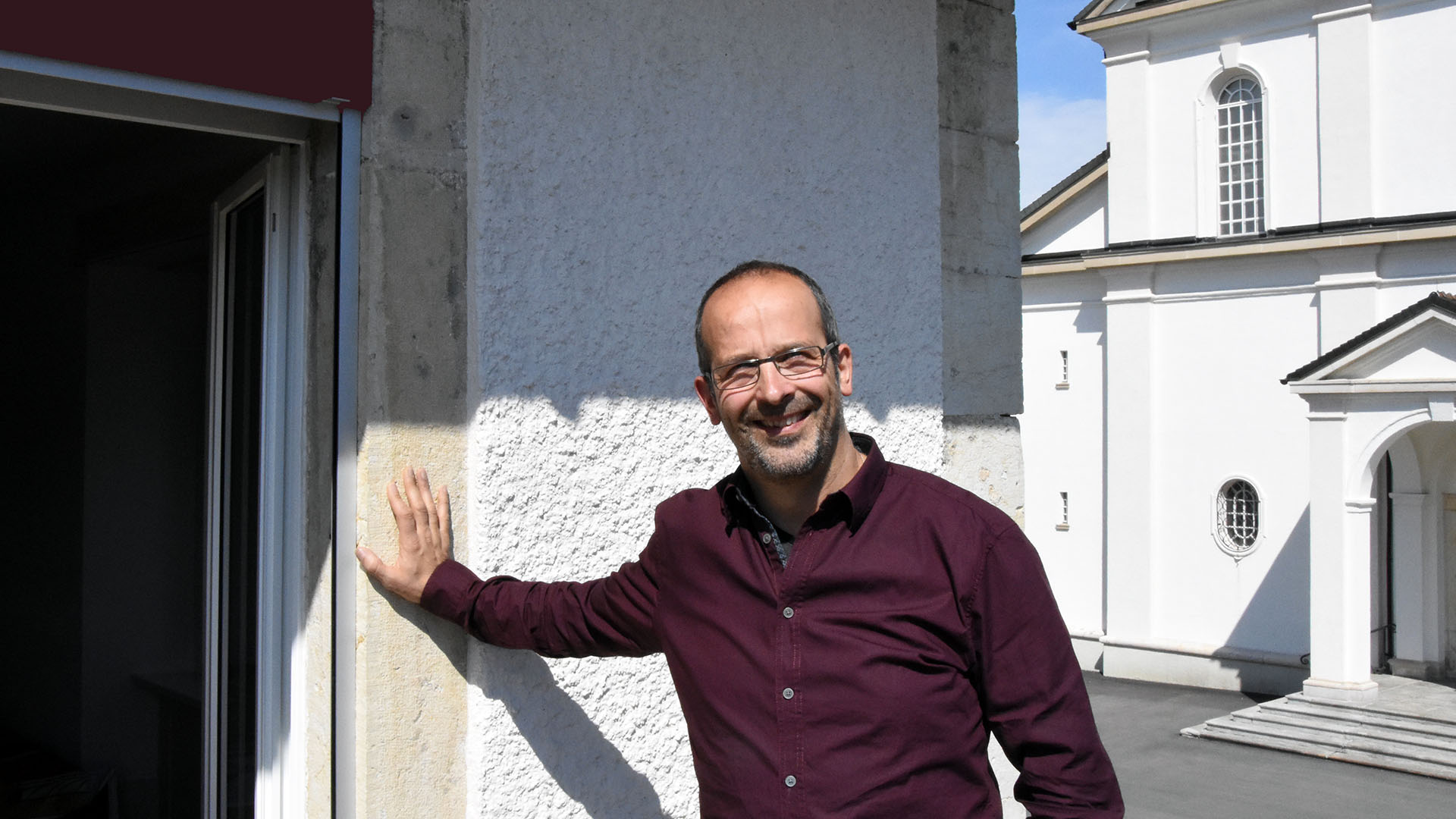 Didier Berret, un diacre responsable de paroisse qui se tient au seuil de l'Eglise. (Photo: Grégory Roth)